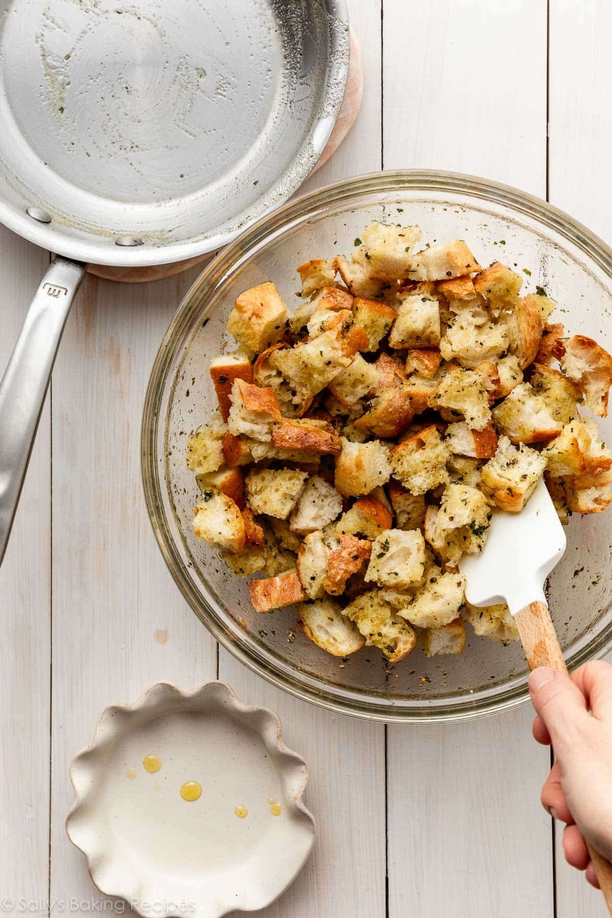 spatula stirring bread cubes in seasoning.