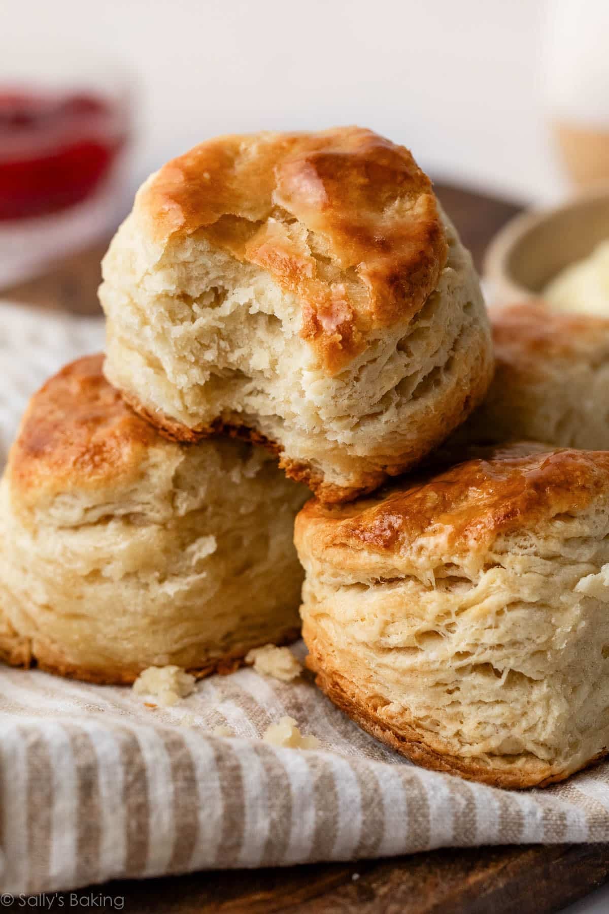 3 homemade biscuits in a pile on striped linen.