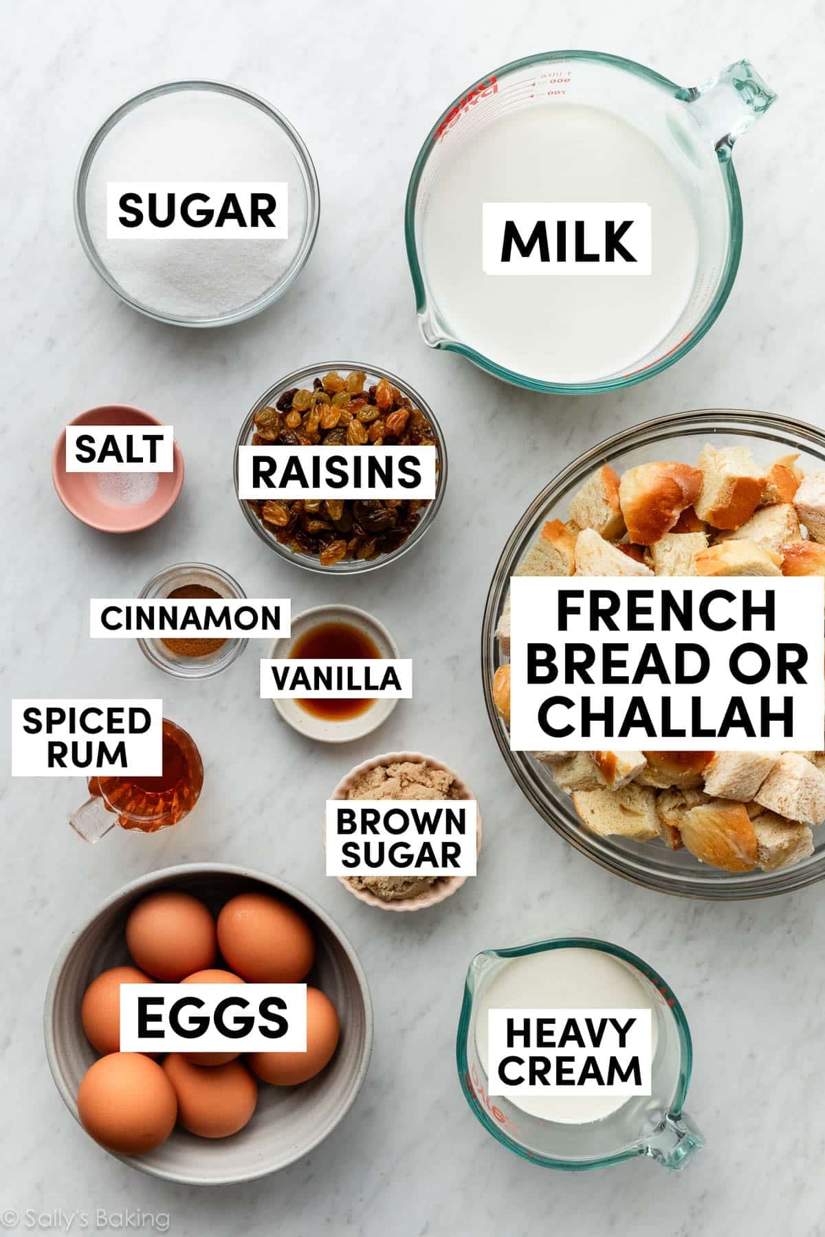 ingredients in bowls including raisins, milk, eggs, cinnamon, brown sugar, and vanilla.