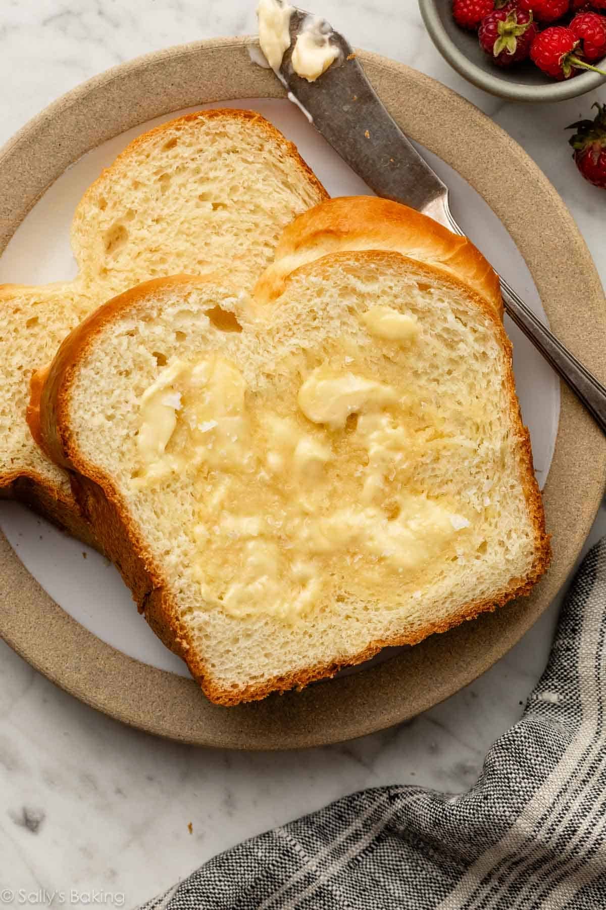 brioche bread slices on plate with butter.