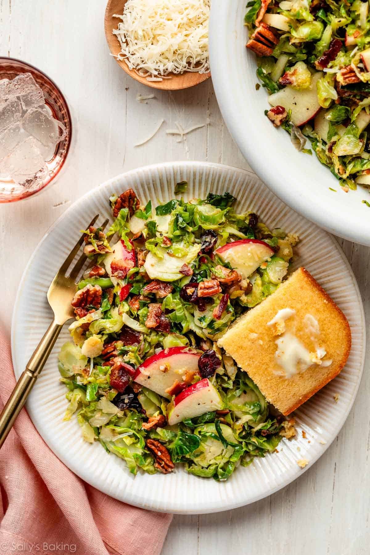 Brussels sprouts salad with bacon on plate with a piece of cornbread.