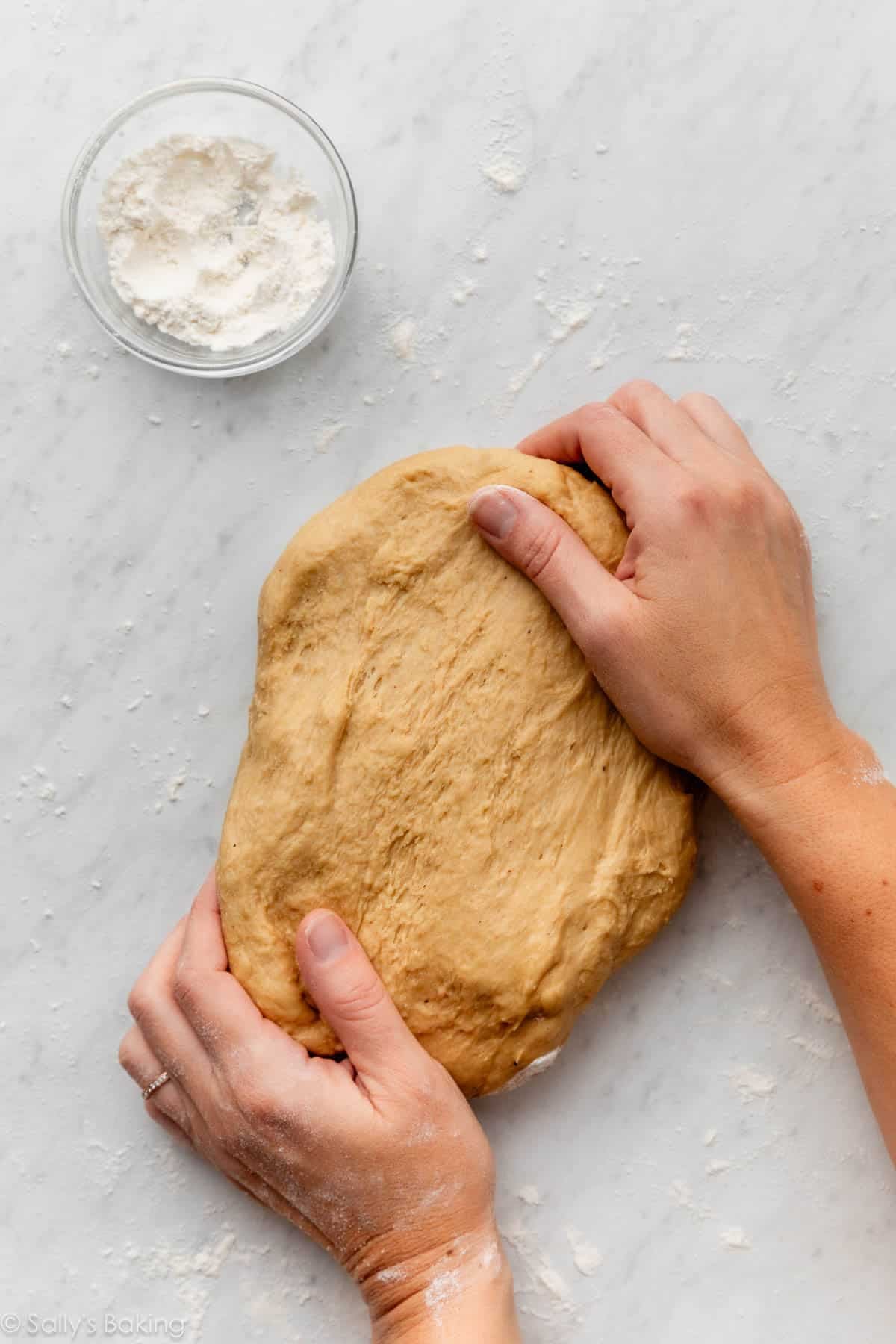 hands kneading dough.