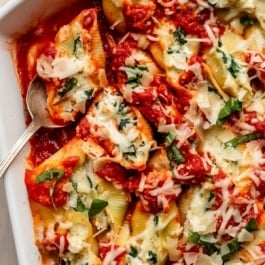 creamy chicken stuffed shells with marinara and garlic spinach.