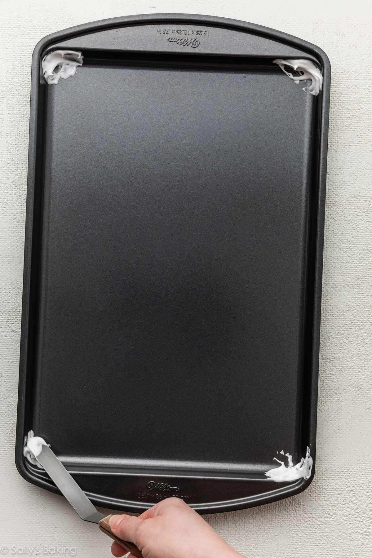 spreading mixture onto corners of pan.